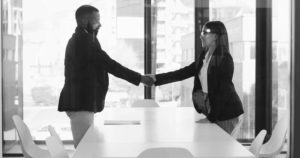 Two business representatives agreeing a commercial collaboration, illustrating the legal differences between a joint venture and a partnership