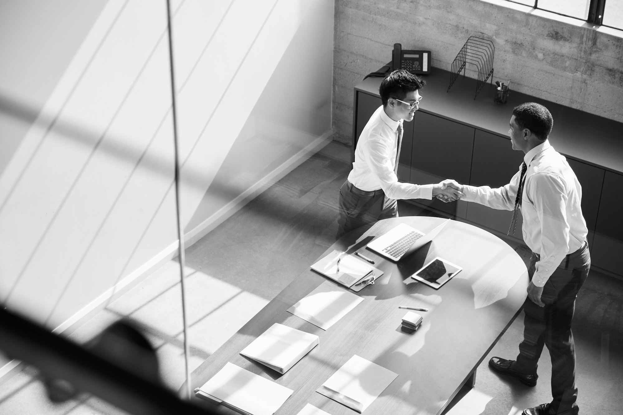 Two business professionals shaking hands to confirm an informal business agreement without a written contrac Two business professionals shaking hands to confirm an informal business agreement without a written contrac
