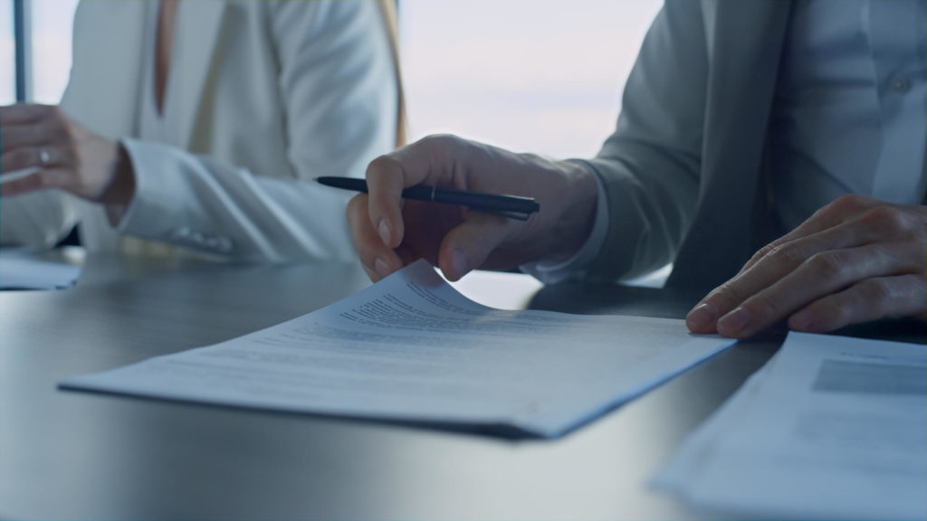 Business shareholders reviewing a shareholder agreement to establish ownership rights and responsibilities within a company.
